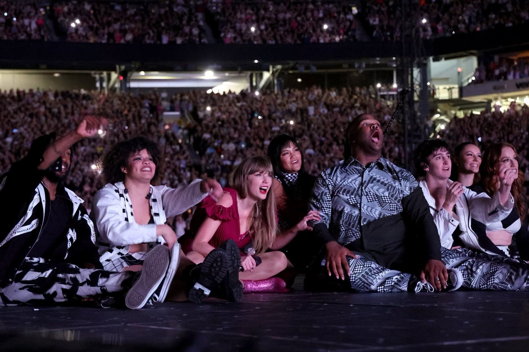Taylor Swift and her dancers watching the premiere of the 'Karma' music video.