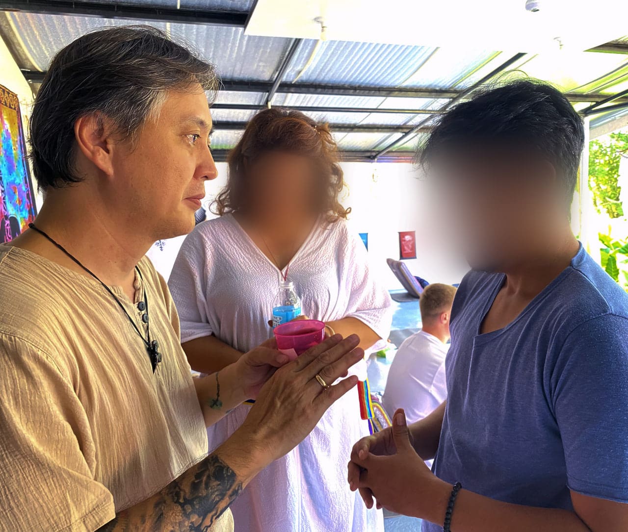 Delong de Leon serves Ayahuasca to a participant