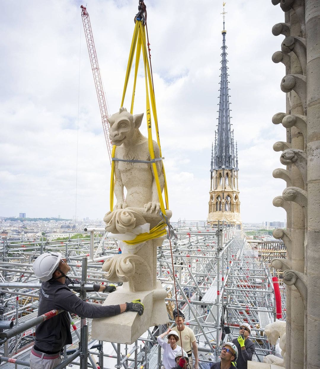 One of the new chimeras taking its place atop the cathedral