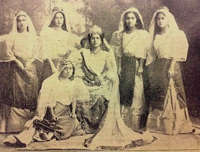 Girls dressed in Filipiniana surrounding Queen of the Carnival winner Paz (middle)