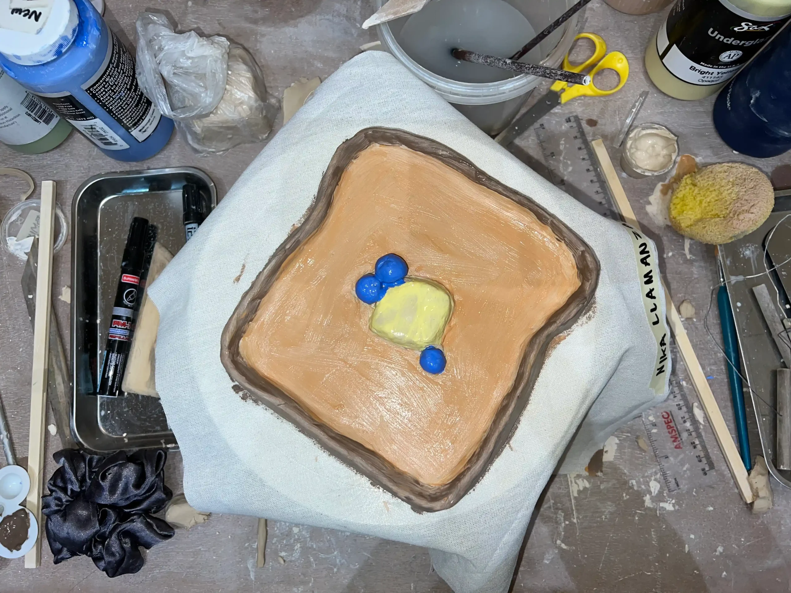 Clay dessert plate meant to look like butter on toast with blueberries/Photo by Nika Llamanzares